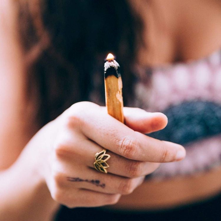 Woman holding lit palo Santo
